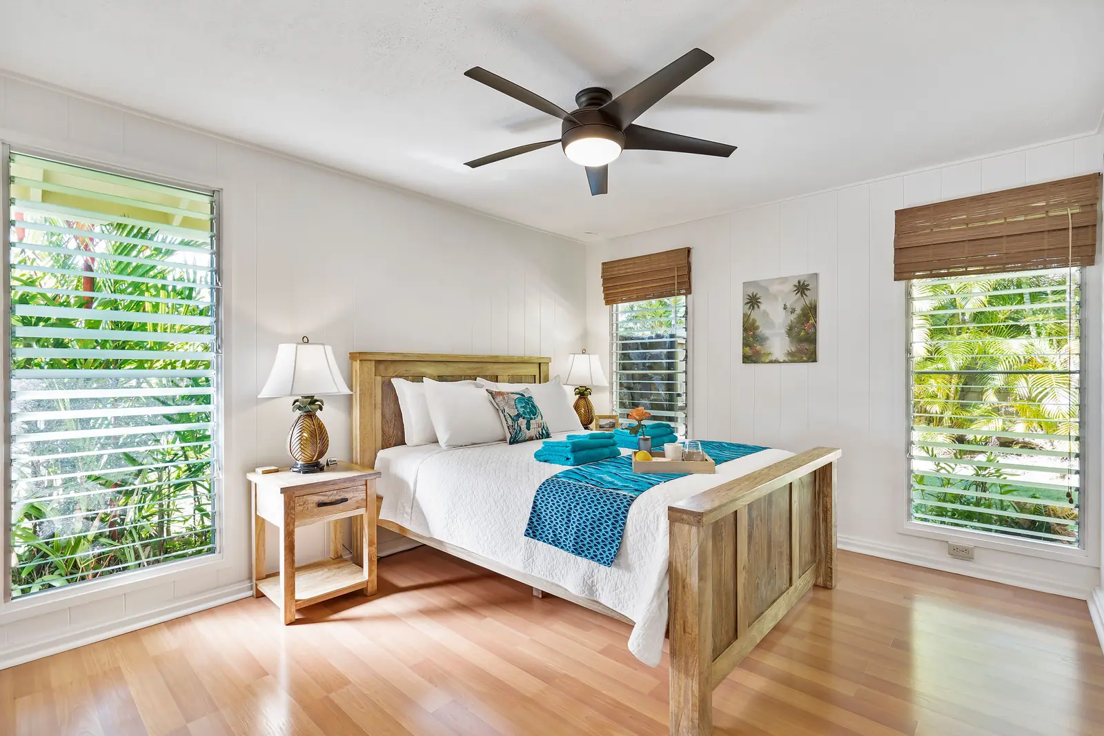 Tropical bedroom with a ceiling fan and wooden furniture