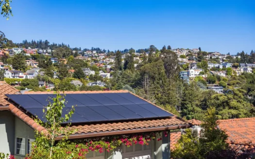 Solar panels installed on the roof of a house surrounded by greenery