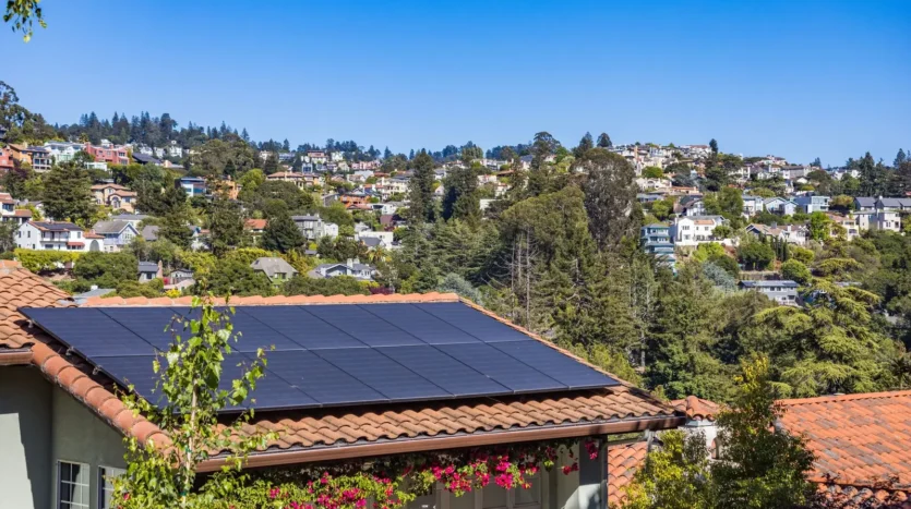 Solar panels installed on the roof of a house surrounded by greenery