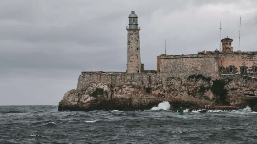 Oleaje junto al Castillo del Morro y su faro en La Habana bajo un cielo gris