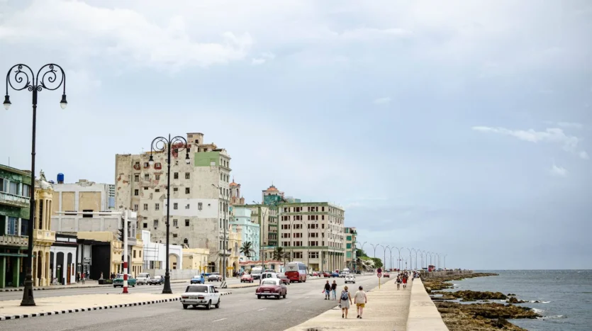 Calle junto al Malecón de La Habana con coches clásicos y el mar al fondo