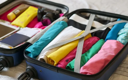 Open suitcase with clothes and travel items neatly packed